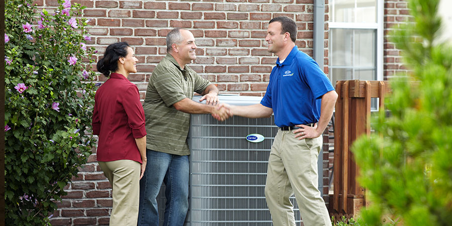 Service technician shaking hands with homeowners