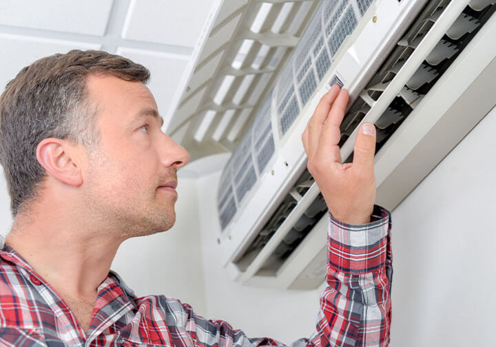 Homeowner adjusting the temperature on his ductless system