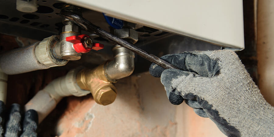 Technician adjusting commercial water heater valves